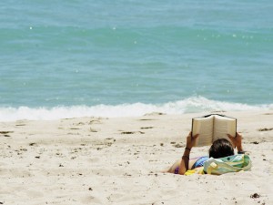 Lector leyendo en la playa